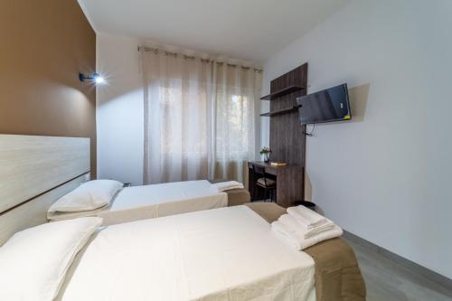 帕尔马Residenza Digione的酒店客房设有两张床和一台平面电视。