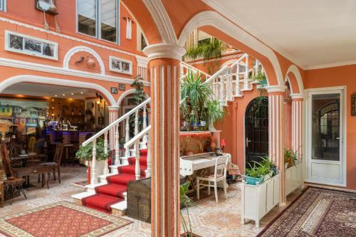 第比利斯Elia Boutique Hostel & Apart-Hotel的拥有红色楼梯和植物的建筑入口