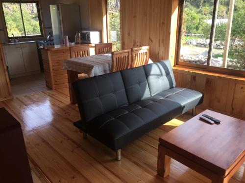 Los QueñesLos Quenes River Lodge的客厅配有沙发和桌子