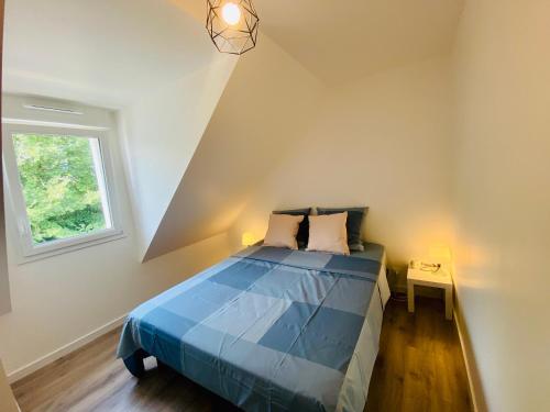 勒帕莱Maison ZETNA ,3 chambres et jardin,Penecam ,Le Palais的一间卧室设有蓝色的床和窗户。