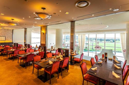 宫崎宫崎ANA假日酒店的餐厅设有桌椅和窗户。