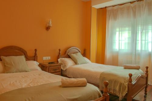 蒙福特·德·莱蒙斯Hostal Galicia的一间卧室设有两张床和窗户。
