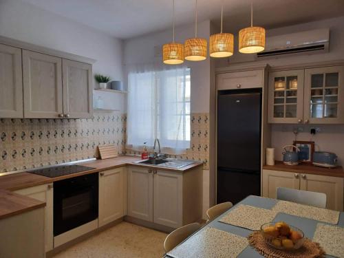 马萨尔福恩Lucky Summer Marsalforn Holiday Apartment的厨房配有白色橱柜和一张带一碗水果的桌子