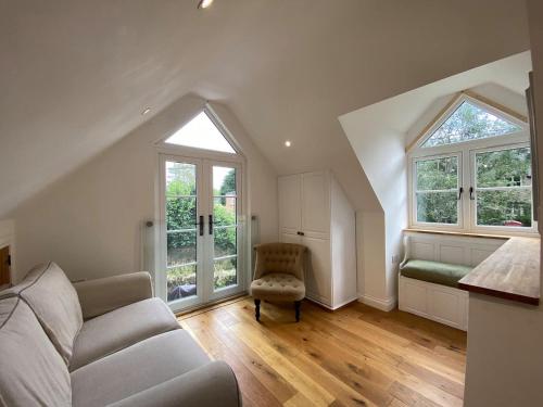 阿斯顿尖塔Candlewick Cottage的带沙发和2扇窗户的客厅