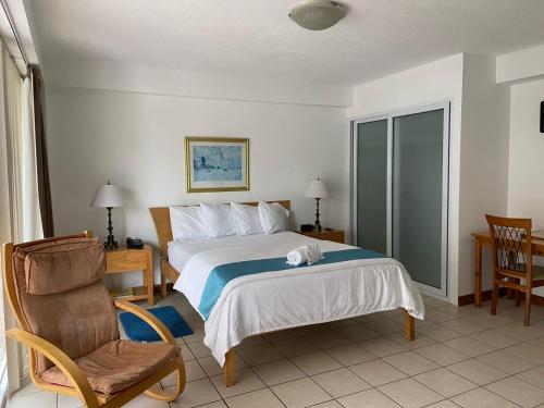 危地马拉雷佛马公寓式酒店的配有一张床和一把椅子的酒店客房