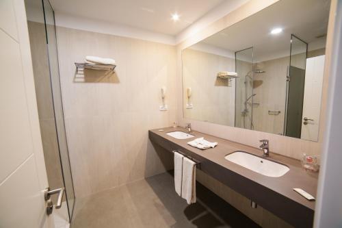 拉克鲁斯圣波隆顿RF酒店的一间带两个盥洗盆和大镜子的浴室