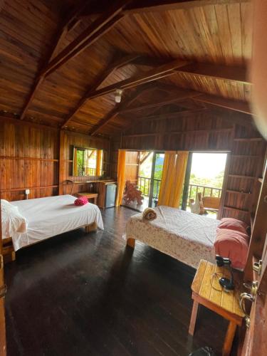 福尔图纳Casa Torre Eco- Lodge的木墙客房的两张床
