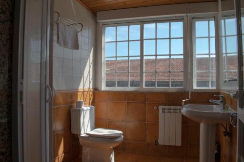 蒙福特·德·莱蒙斯Hostal Galicia的一间带卫生间、水槽和窗户的浴室