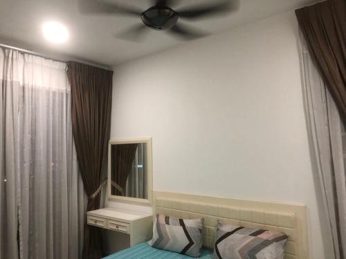 怡保R&C Homestay 5的一间卧室配有吊扇和一张带镜子的床