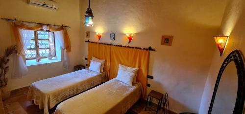 斯库拉艾特本摩洛黛米耶特酒店的一间卧室设有两张床和窗户。