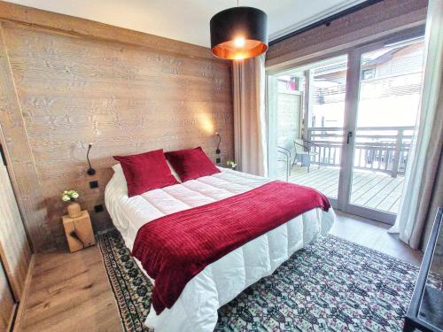 莱热Appartement Les Gets, 4 pièces, 6 personnes - FR-1-598-78的一间卧室配有一张带红色枕头的大床