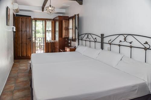纳瓦孔塞霍Hotel Rural Xerete的一间卧室配有一张带白色床单的大床