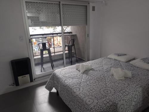 罗萨里奥Alquiler Temporario Rosario 4的一间卧室配有带两个枕头的床和窗户