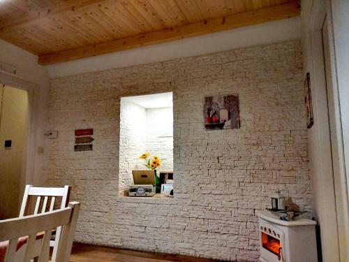 莫尔费塔La Maison apartment的厨房设有白色砖墙和窗户