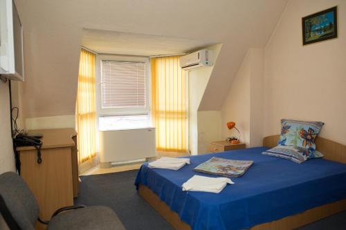 桑丹斯基德瓦酒店的一间卧室设有蓝色的床和窗户。