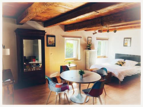Ay-sur-MoselleChâteau de Logne的卧室配有一张床和一张桌子及椅子