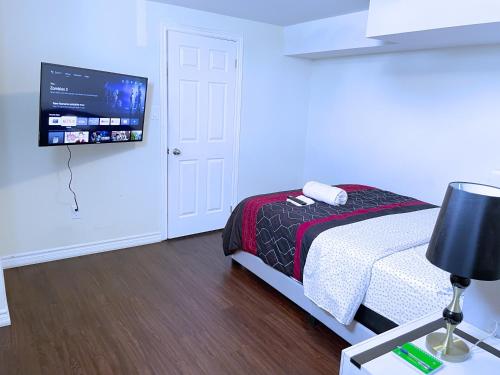 InnisfilWELCOME TO PREMIUM LIVING PLACE / 2 BEDROOMS SUITE的一间卧室配有一张床和一台平面电视