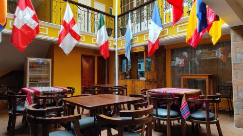 拉巴斯Wake Up Hostel的餐厅设有木桌、椅子和旗帜