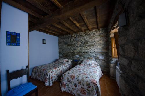 BoalA Casua的一间卧室设有两张床和石墙