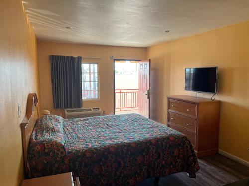 北山Palm Tree Inn的一间卧室配有一张床和一台平面电视