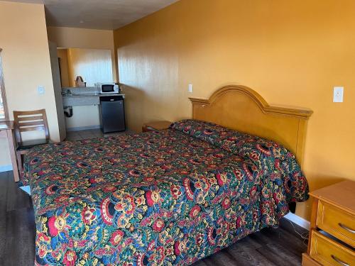 北山Palm Tree Inn的一间卧室配有一张带彩色床罩的床