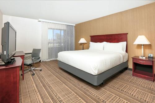 圣玛丽亚Holiday Inn & Suites Santa Maria, an IHG Hotel的配有一张床和一台平面电视的酒店客房