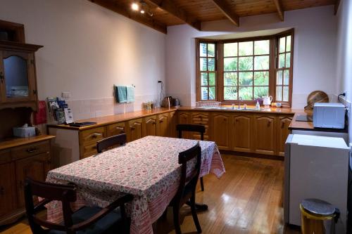 Gellibrand盖利布兰德河画廊度假屋的厨房配有桌子和桌布