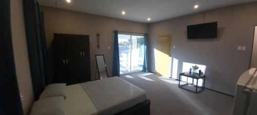 帕拉马里博Waterland Suites的一间卧室设有一张床和一个滑动玻璃门