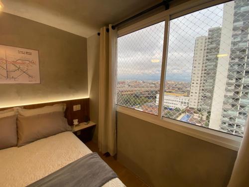 圣保罗Maravilhoso Apartamento em frente ao Metrô Brás !的一间卧室设有一张床和一个大窗户