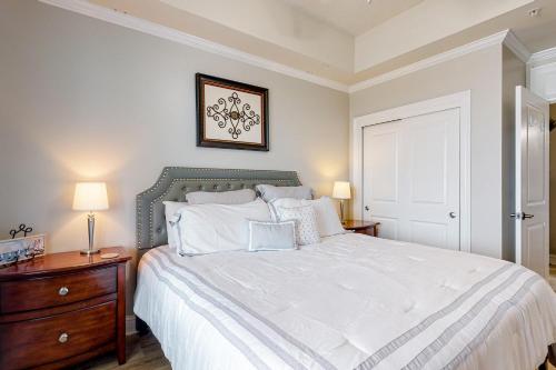 奥兰治比奇The Wharf 811的卧室配有白色大床和木制梳妆台