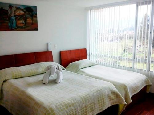 杜伊塔马Hotel Santris的一间卧室配有两张床,并备有毛巾