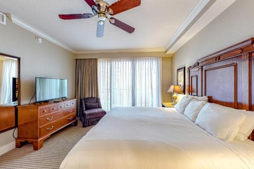 德斯坦Emerald Grande 324的一间卧室配有一张大床和吊扇
