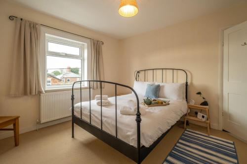 莱斯顿40 Buller Road - Aldeburgh Coastal Cottages的一间卧室设有一张床和一个窗口