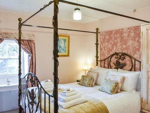 KirkoswaldStaffield Cottage的一间卧室配有一张四柱床和毛巾