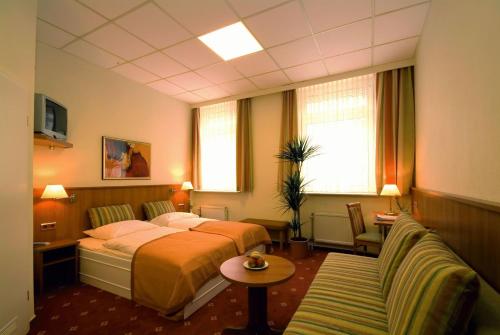 吕贝克旅行者酒店的酒店客房,配有床和沙发