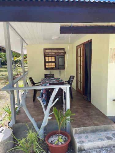 阿瓦托鲁Rangiroa Guest Paradise的一个带桌椅的房屋门廊
