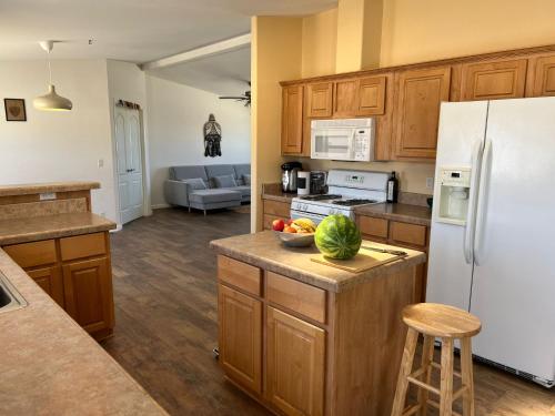 二十九棕榈村Bodhi House, Joshua Tree National Park的厨房配有木制橱柜和白色冰箱。