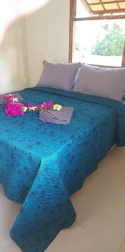 阿瓦托鲁Rangiroa Guest Paradise的一张蓝色的床,上面有鲜花