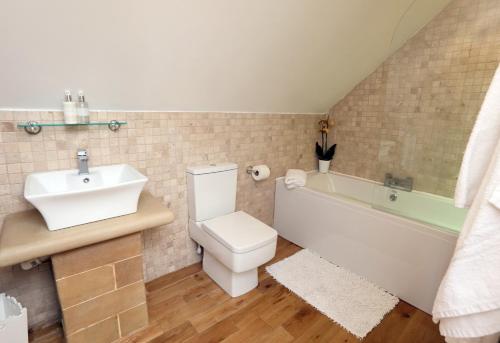 巴斯洛荒地景致旅馆的浴室配有盥洗盆、卫生间和浴缸。