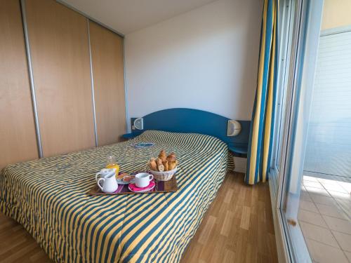 比亚里茨梅尔欧仁妮高尔夫酒店的一间卧室配有一张床,上面放着一个食物托盘