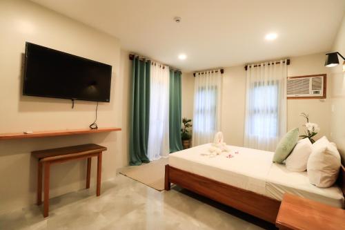 布桑加Josefina's Tourist Inn的一间卧室配有一张床和一台平面电视