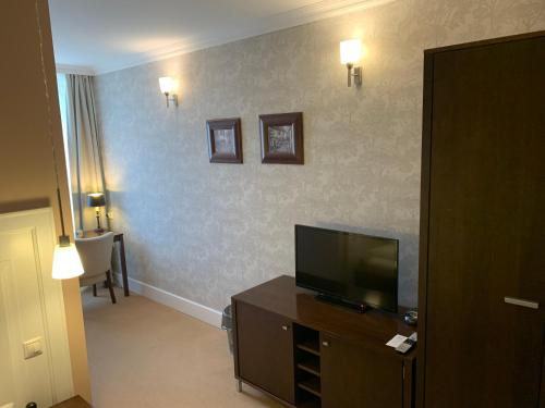 Želiezovce伊甸园宾馆的酒店客房设有电视和客厅。