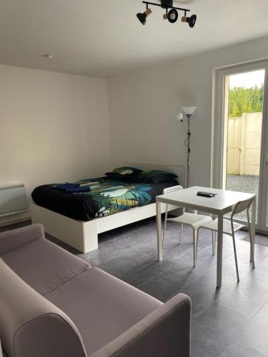 GaillonStudio le cosy centre de gaillon(wifi)的一间卧室配有一张床、一张桌子和一张沙发