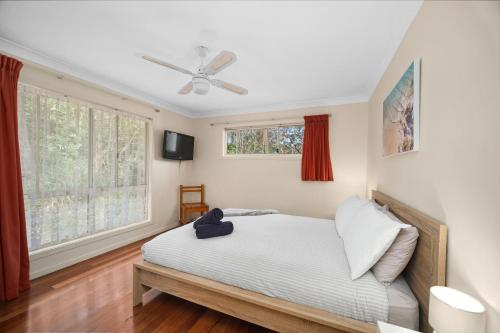 史密斯湖水上远景公寓的一间卧室配有一张床和吊扇