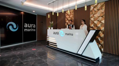 伊斯坦布尔AURA MARINA HOTEL的两个人站在大厅的柜台上