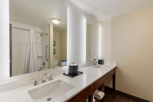 拉夫兰Comfort Suites Loveland的一间带两个盥洗盆和大镜子的浴室