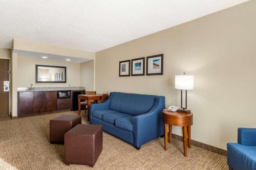 克利尔沃特Comfort Inn & Suites St Pete - Clearwater International Airport的客厅配有蓝色椅子和桌子