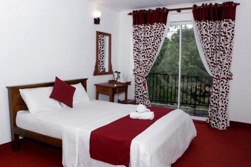 康提Sadhara River View Lodge的一间卧室设有一张大床和一个窗户。