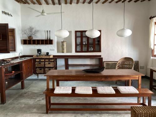 莫桑比克岛Casa Fabula的一间带桌子的客厅和一间厨房