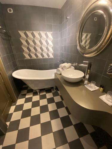 圣雷米普罗旺斯Hôtel Gounod的带浴缸、水槽和镜子的浴室